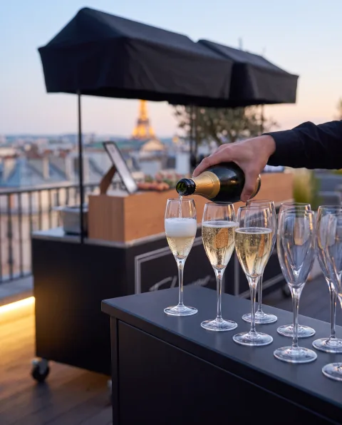 Champagne versé dans une série de flûtes, toit-terrasse parisien